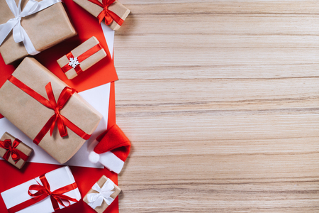 Border of gift boxes on wooden background. Christmas composition. Top view, flat lay. Mock up, copy space for your text.の写真素材