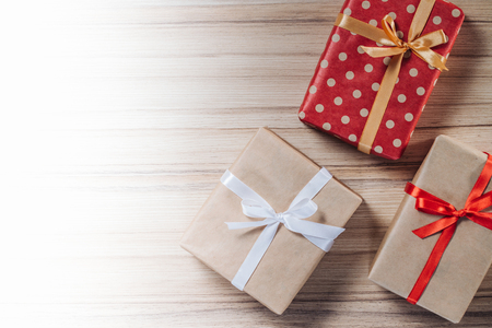 Border of gift boxes on wooden background. Christmas composition. Top view, flat lay. Mock up, copy space for your text.の写真素材