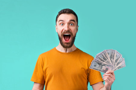 Euphoric football fan celebrating his favourite team victory and money win at bookmaker's website showing sincere excitement screaming and laughing.の写真素材