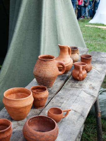 Historical medieval festival, Viking camp, pottery on a wooden bench.の写真素材