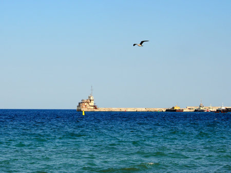 The old port control room on the pier, the far-off plan against the blue sea. Infrastructure of the...