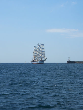 A sailing ship with white sails on three masts at sea. The concept of a cruise, vacation at sea, sailing, yachting.の写真素材