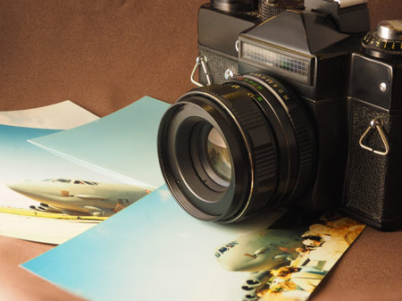 Still life with an old film, SLR camera and printed photos, close-up. Accessories of the film era of...