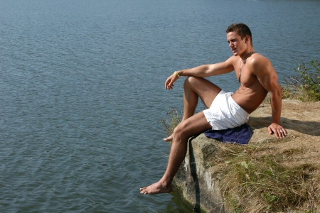 Muscular male model with army tags on the beachの写真素材