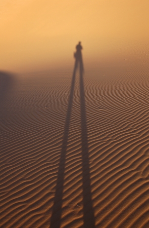 Human shadow in the sand dunes of Erg Chebbi in the Sahara Desert, Morocco の写真素材
