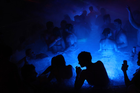 BUDAPEST, HINGARY - NOVEMBER 2, 2013: Tourists enjoy the Magic Bath Party at the Lukacs Bath, a traditional night party in a historic outdoor thermal bath heated naturally by hot springs, in Budapest, Hungary, on November 2, 2013.のeditorial素材