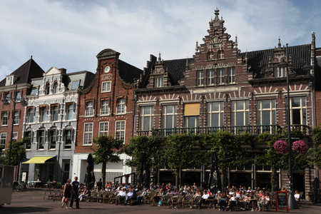 HAARLEM, NETHERLANDS - AUGUST 9, 2012: People sit in a cafe in front of the traditional Dutch houses on the Grote Markt in Haarlem, North Holland, Netherlands.のeditorial素材