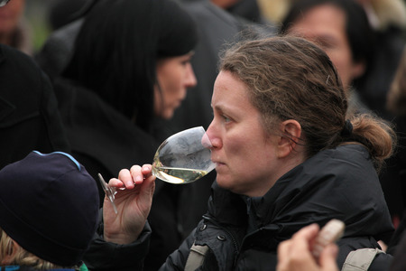 PRAGUE, CZECH REPUBLIC - NOVEMBER 11, 2012: Woman tastes young wine during the celebration of Saint Martin Day in Prague, Czech Republic.のeditorial素材