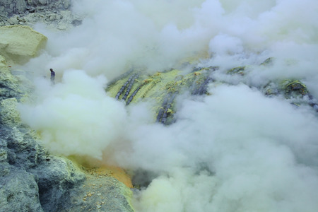 KAWAH IJEN, INDONESIA - AUGUST 8, 2011: Miners collect sulphur in the fumes of toxic volcanic gas at the sulphur mines in the crater of the active volcano of Kawah Ijen, East Java, Indonesia.のeditorial素材