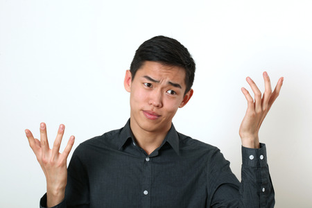 Displeased young Asian man gesturing with two hands.の写真素材