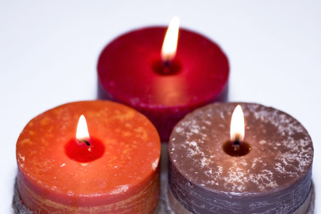 Three colorful burning candlesの写真素材