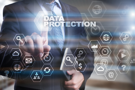 Businessman is pressing on the virtual screen and selecting "Data protection".の写真素材