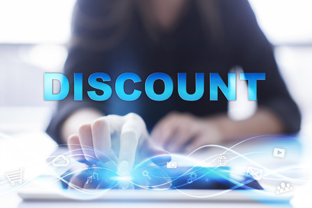 Woman is using modern tablet pc, presssing on touch screen and selecting "Discount".の写真素材