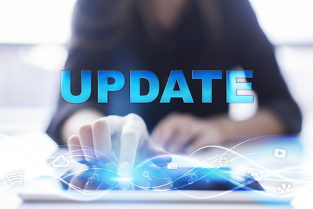 Woman is using modern tablet pc, presssing on touch screen and selecting "Update".の写真素材