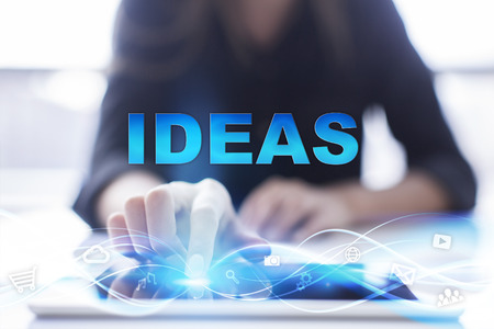 Woman is using modern tablet pc, presssing on touch screen and selecting "Ideas".の写真素材