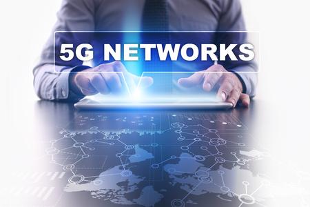 Businessman is using tablet pc, pressing on virtual screen and selecting 5g networks.の写真素材