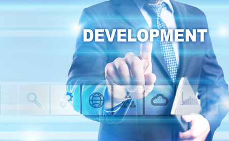 Businessman pressing button on touch screen interface and selecting Development.の写真素材