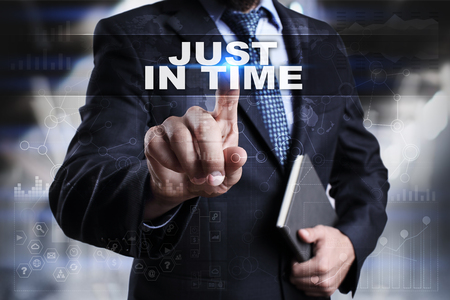 Businessman is pressing button on touch screen interface and selecting just in time.の写真素材