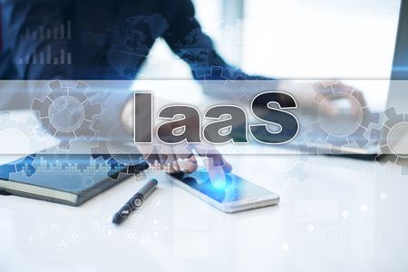 Businessman working in office, pressing button on virtual screen and selecting iaas.の写真素材