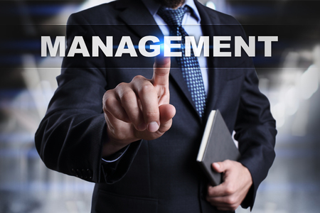 Businessman is pressing button on touch screen interface and selecting management.の写真素材