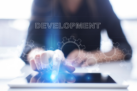 Woman is using tablet pc, pressing on virtual screen and selecting development.の写真素材