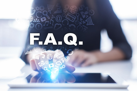 Woman is using tablet pc, pressing on virtual screen and selecting f.a.q..の写真素材