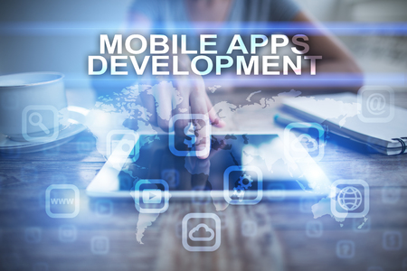 Woman using tablet pc, pressing on virtual screen and selecting mobile apps development.の写真素材
