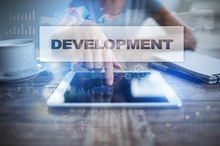 Woman using tablet pc, pressing on virtual screen and selecting development.の写真素材