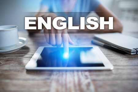 Woman using tablet pc, pressing on virtual screen and selecting english.の写真素材