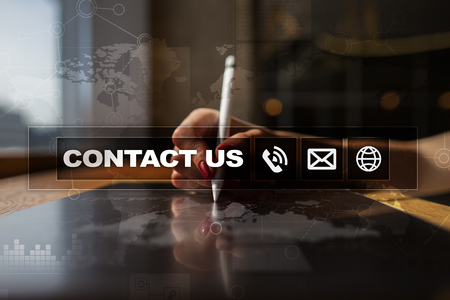 Contact us button and text on virtual screen. Business and technology concept.の写真素材