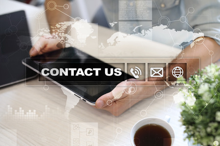 Contact us button and text on virtual screen. Business and technology concept.の写真素材