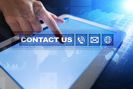 Contact us button and text on virtual screen. Business and technology concept.の写真素材