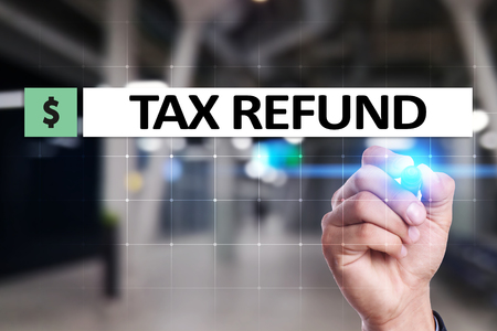 Tax refund text on virtual screen. Business and Finance concept.の写真素材