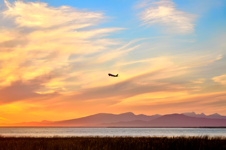Sunset. Sunset Sky. A plane is attempting to climb in the sunset sky.の写真素材
