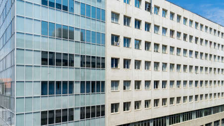 Bucharest, Romania- JUNE 15, 2019: Modern office building filling the frame with long rows of square windows pattern and white facade with glass block on the side; on George Enescu street in downtown on a clear sunny day. Modern architecture.のeditorial素材