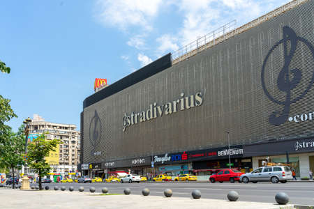 Bucharest, Romania- June the 17th, 2019: Huge Stradivarius billboard mounted on a shopping mall's wall on Union Square (Piata Unirii) on a clear sunny day. Advertisement and marketing.のeditorial素材