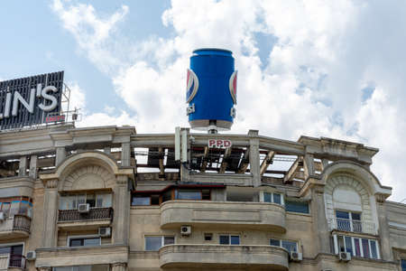 Outdoor advertising of a large spinning can of Pepsi, set on top of the residential building at Union Square (Piata Unirii), in Bucharest, Romania. Marketing and advertising.のeditorial素材