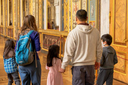 Family, man and woman with three children with their backs to us at the exhibition in the Hermitage...