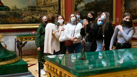 Tour guide talking to a group of female visitors in ppe face masks in the reopened Hermitage museum, St. Petersburg, Russiaのeditorial素材