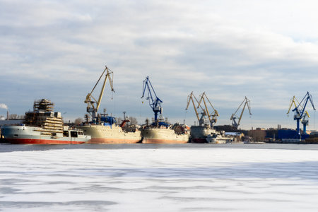ST PETERSBURG, RUSSIA-MARCH 31, 2021: Container ships and cranes in the port of St Petersburg on ice covered, thawed Neva riverのeditorial素材