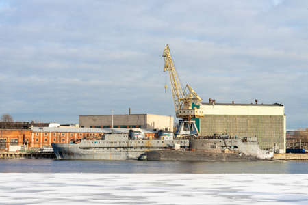 ST PETERSBURG, RUSSIA-MARCH 31, 2021: diesel-electric attack submarine of kilo-class, vessel, and a cargo crane in the port of St Petersburg on the thawing ice of the Neva river.のeditorial素材