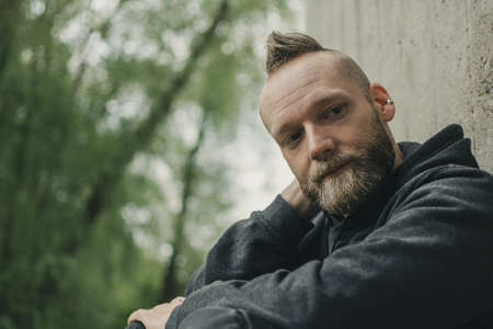 happy satisfied young man sitting on the groundの写真素材
