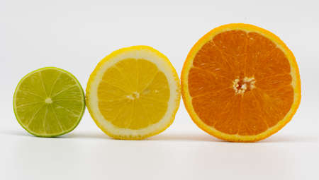 slices of a lime, a lemon and a orange in front of a white backgroundの写真素材