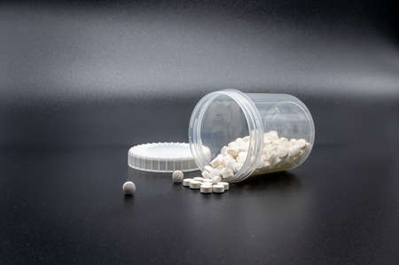 pills fall out of an overturned plastic can