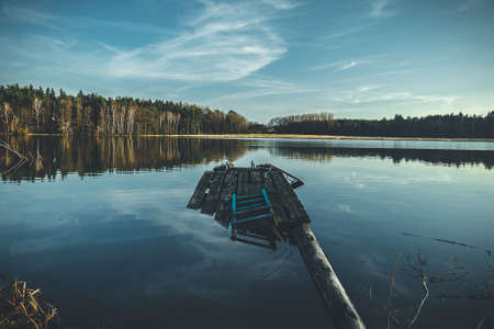 a broken jetty on a lake in the forestの写真素材
