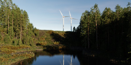 two wind turbines in a forest with clear skies and sunshine - 3D Illustrationの写真素材