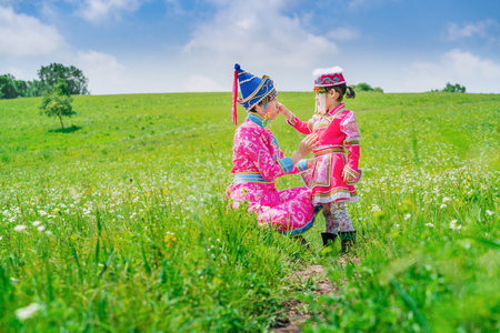 Mother and daughter wearing Mongolian costumes on the grasslandの写真素材