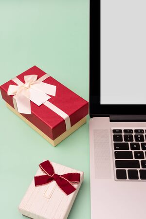 Laptop and gift boxes on green backgroundの写真素材