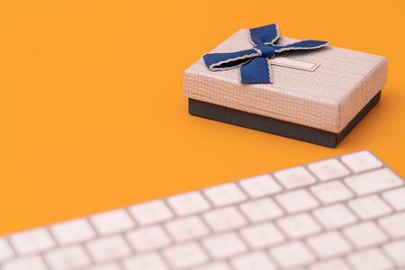 Gift box and computer keyboard on yellow backgroundの写真素材