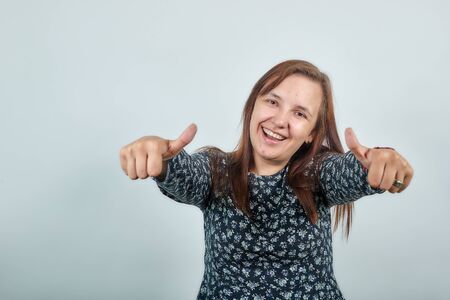 brunette girl in dark blouse over isolated white background shows emotionsの写真素材